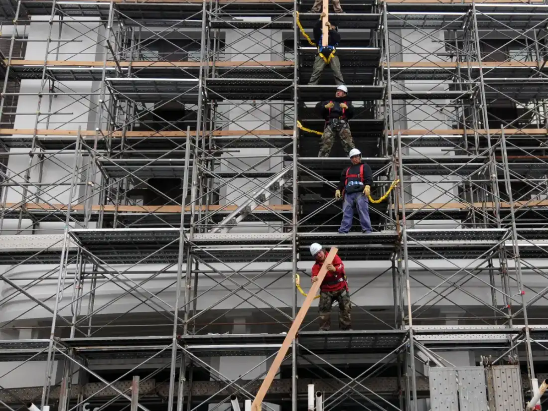 Operarios en un andamio trabajando en la fachada de un edificio