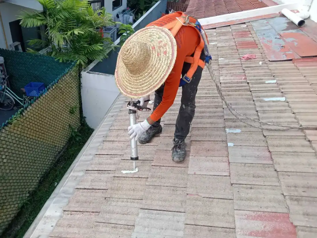 Operario sellando juntas en un tejado para reparar filtraciones